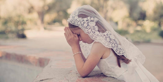 little girl at her first communion wearing a pearl rosary and matching necklace.