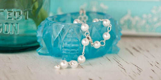 A guide to everything you know about freshwater pearls - pearls in a vintage blue french glass.