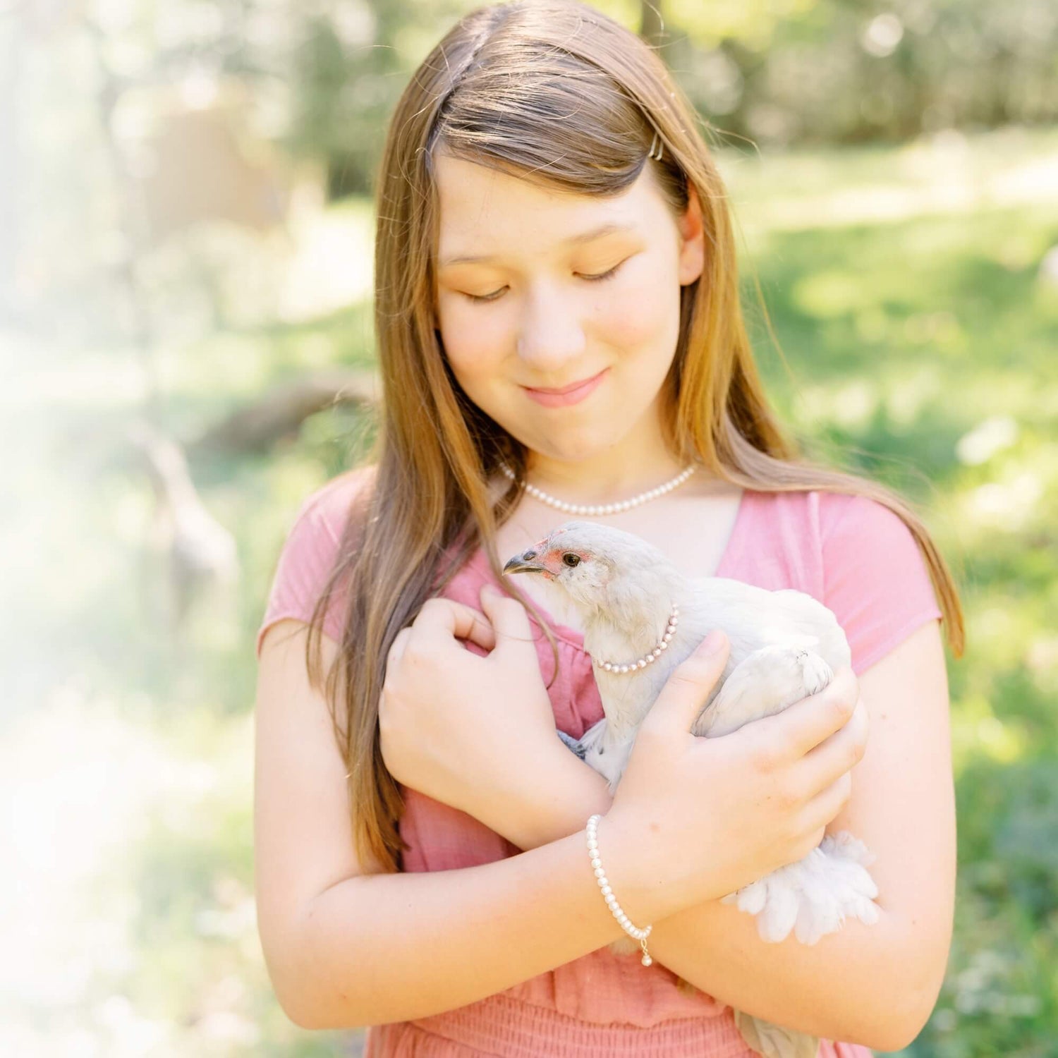 teenage girl holding a chicken - everyone is wearing pearls, even the chicken!