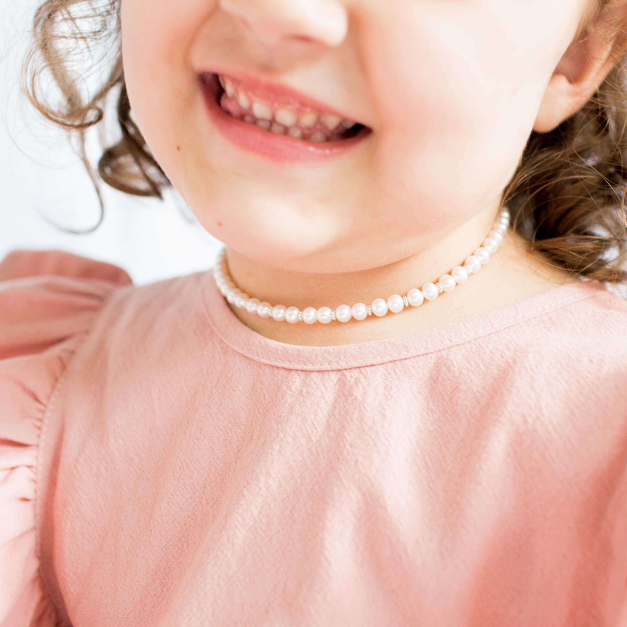 High-Angle Shot of a Baby Wearing a Pearl Necklace while Eating Frosting ·  Free Stock Photo